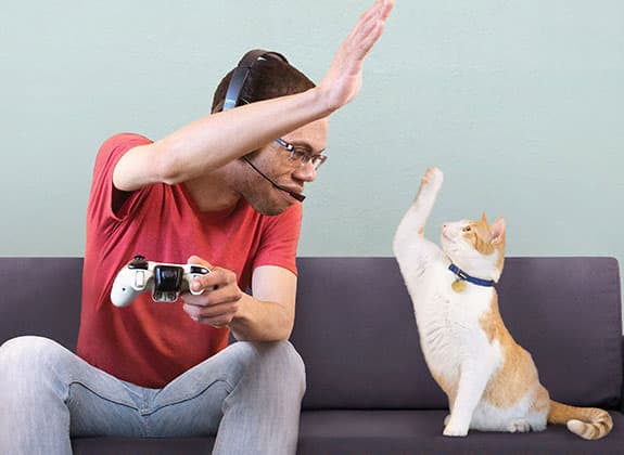 man doing a high five with his cat